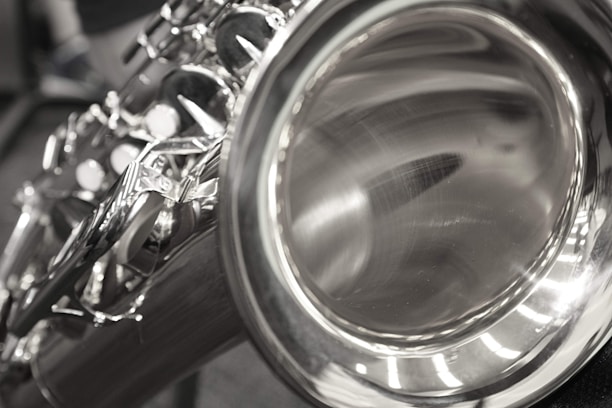 A close-up view of the bell and keys of a shiny saxophone, with a focus on the reflective metal surface and intricate keywork.