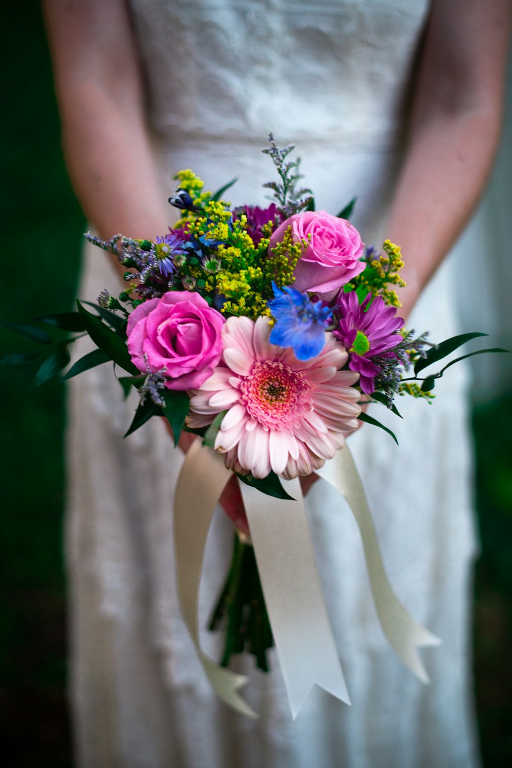 woman holding pink and white flower bouquet