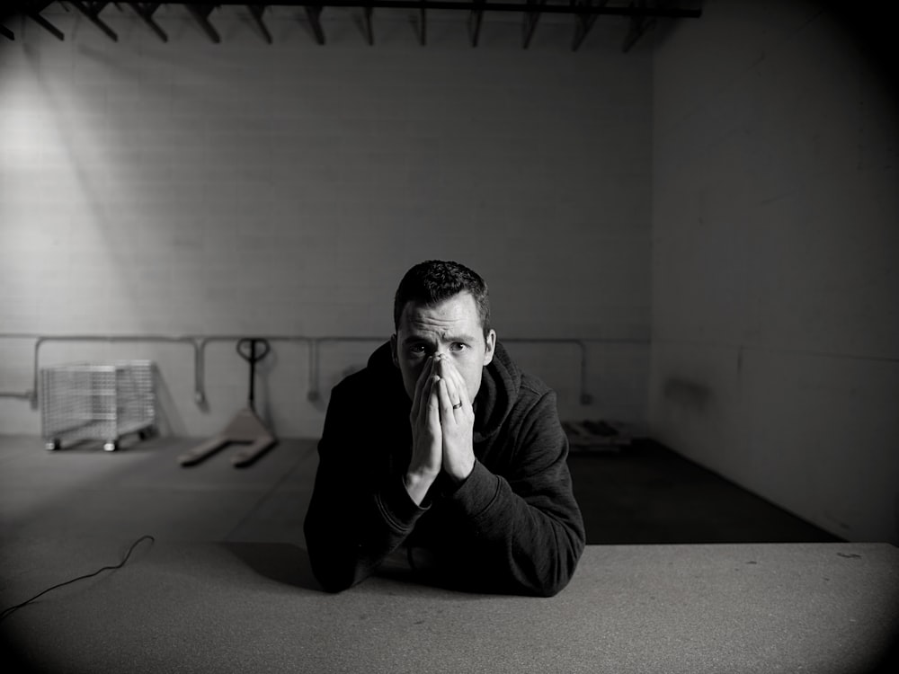 man in black jacket sitting on floor