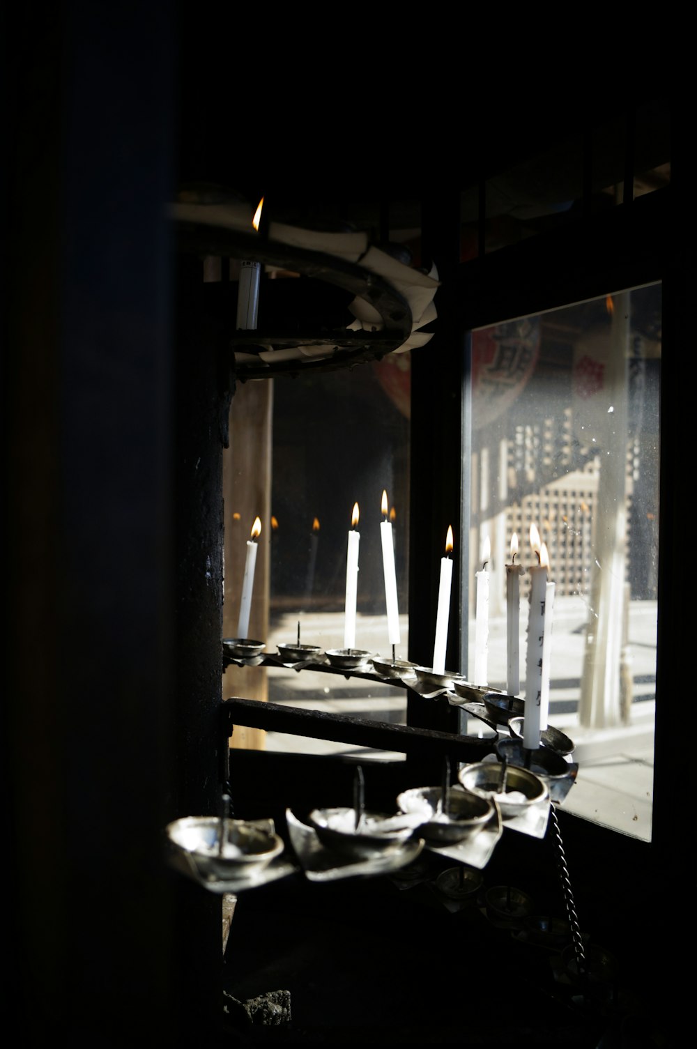 lighted candles on table near window