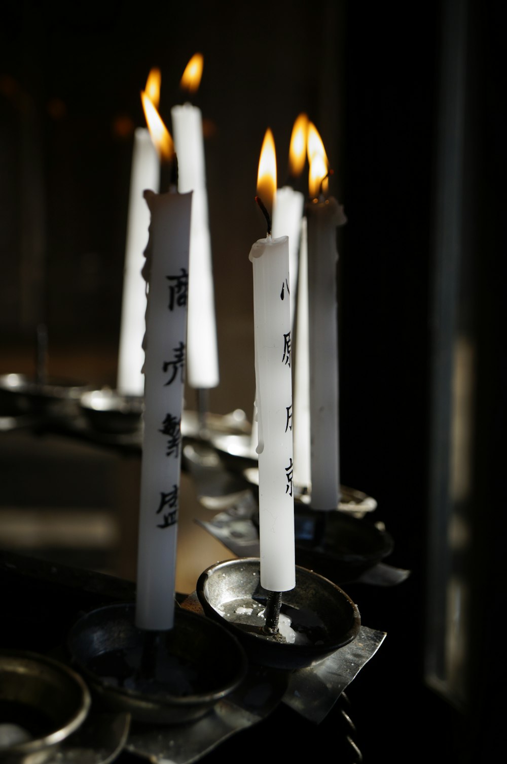 white lighted candles on silver holder