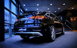 A sleek black luxury SUV parked in a modern showroom with soft lighting.