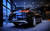 A fleet lineup of premium cars including Mercedes Classe E, V, S, and Tesla under soft lighting.