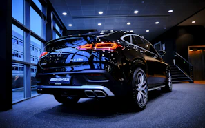 A sleek black luxury SUV parked in a modern showroom with soft lighting.