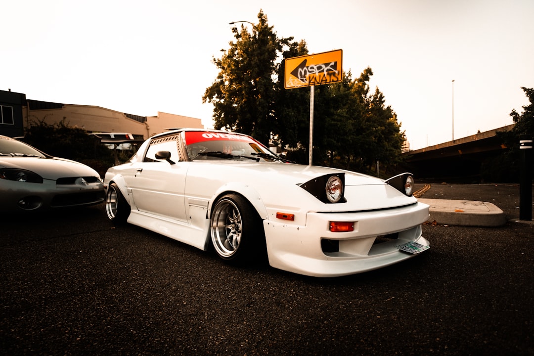 white porsche 911 parked on black asphalt road during daytime