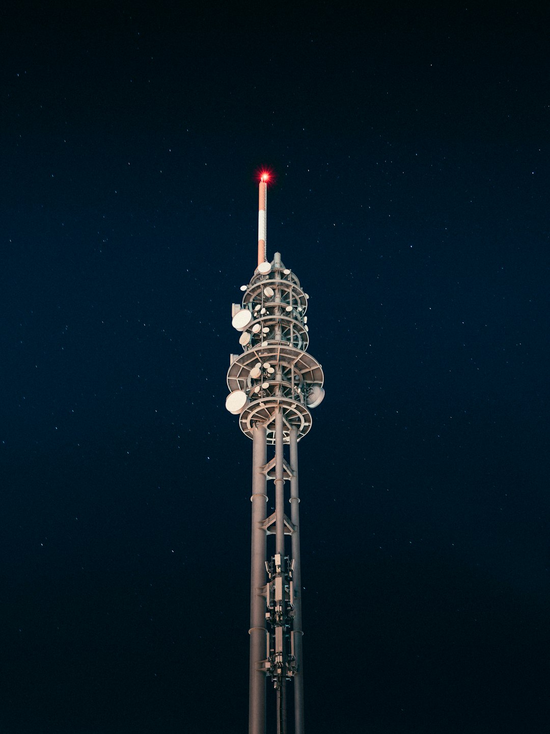 silver tower with red light during night time