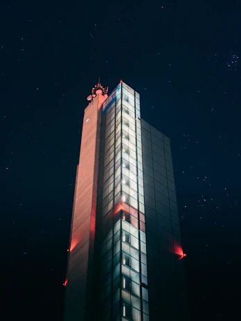 Outdoor LED modem installed on a building facade with city lights in the background