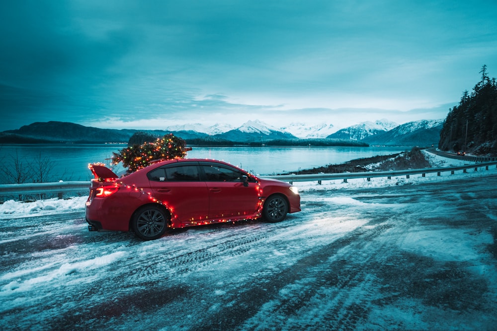 red sedan on snow covered ground during daytime