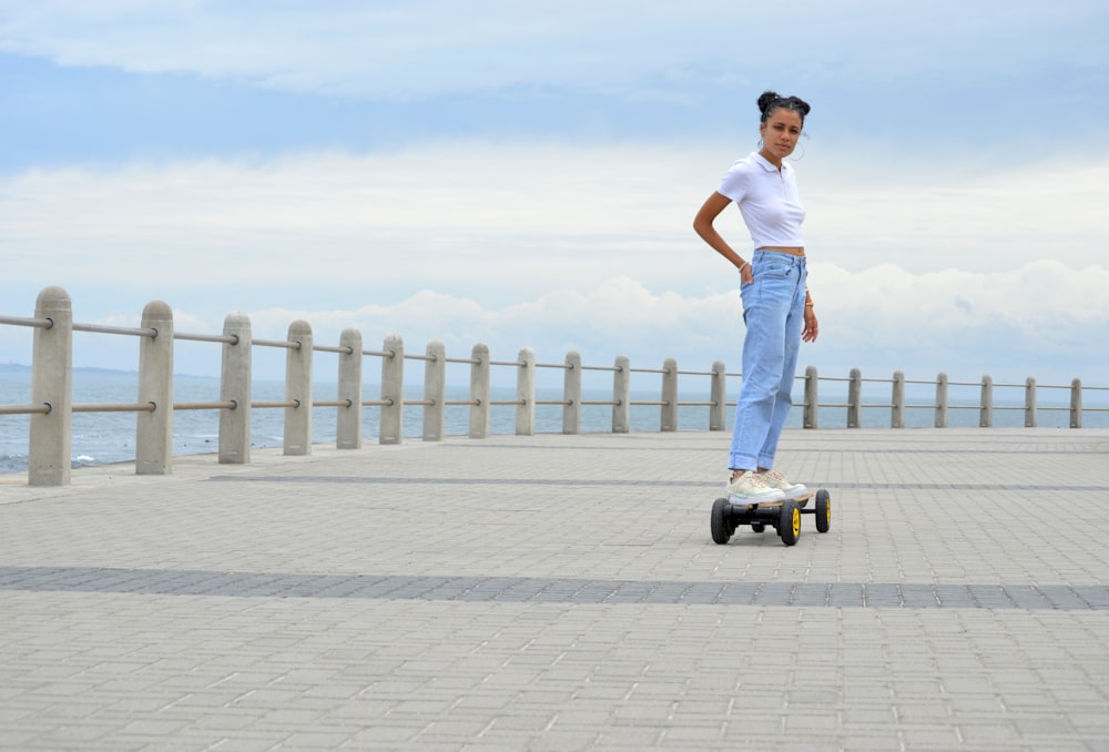 man in white tank top and blue denim jeans standing on gray concrete floor during daytime