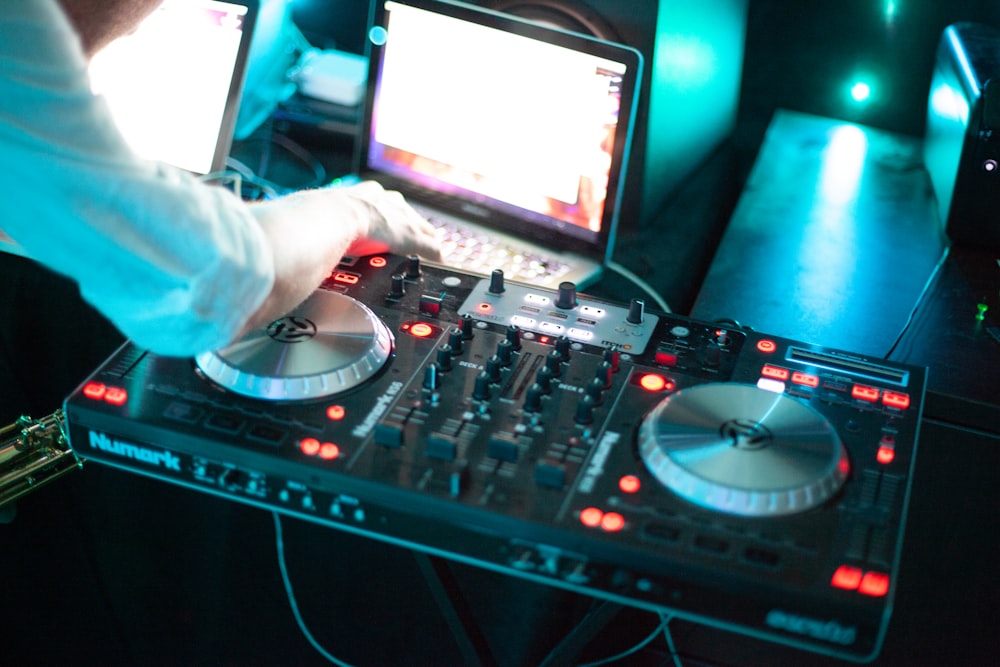 person playing dj controller with audio mixer