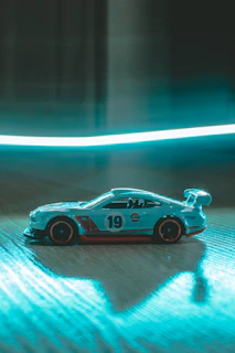 A vibrant remote-controlled car speeding across a smooth blue surface