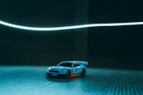 Close-up of a vibrant Hot Wheels car racing with colorful streaks behind.