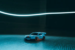 Close-up of a vibrant Hot Wheels car racing with colorful streaks behind.