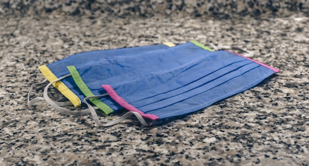 A collection of colorful sheet masks displayed artistically on a marble countertop.