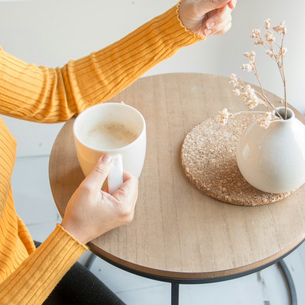 person holding white ceramic mug