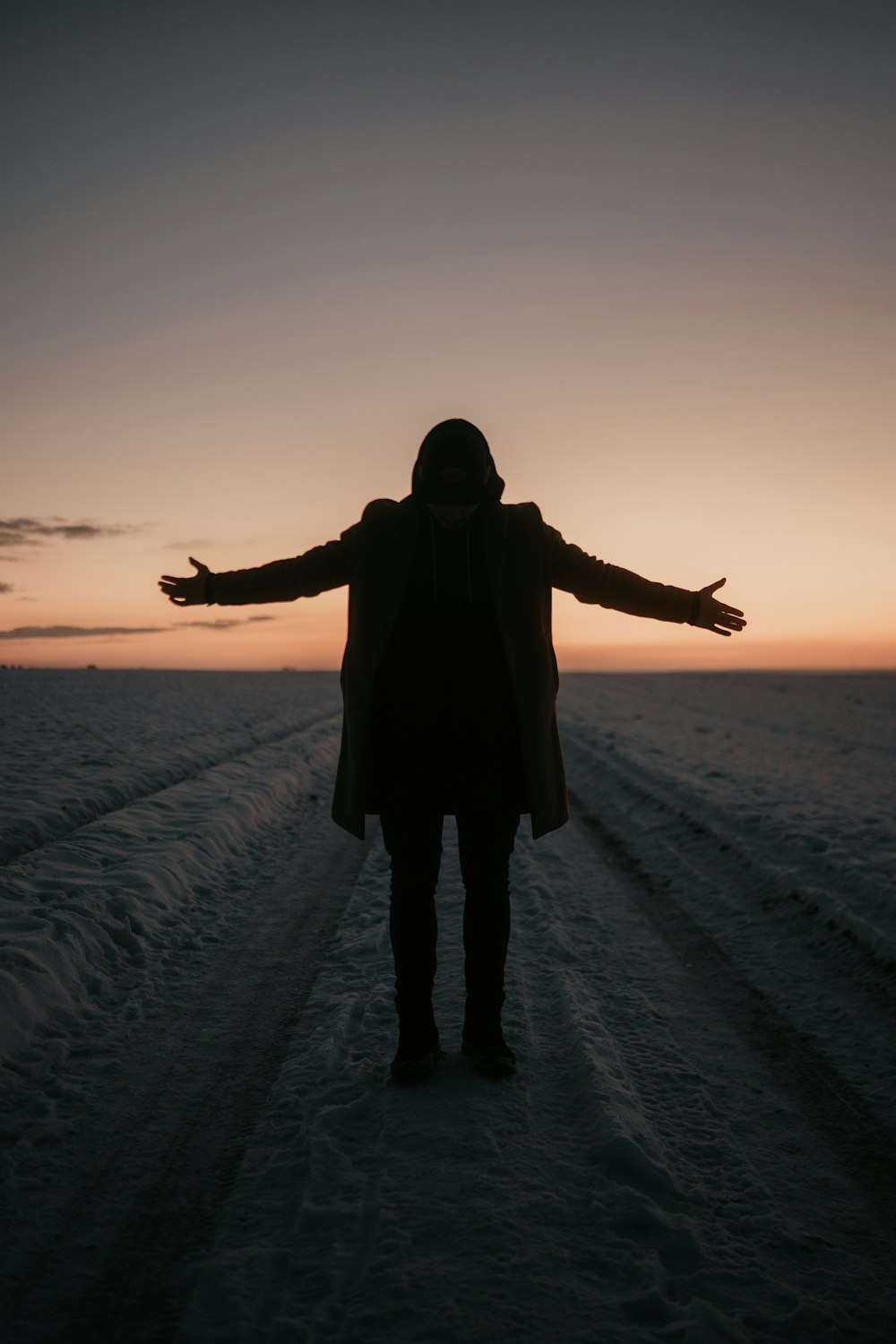 man in black jacket standing on snow covered ground during daytime