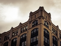 brown concrete building under white clouds during daytime