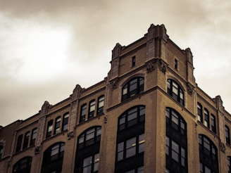 brown concrete building under white clouds during daytime