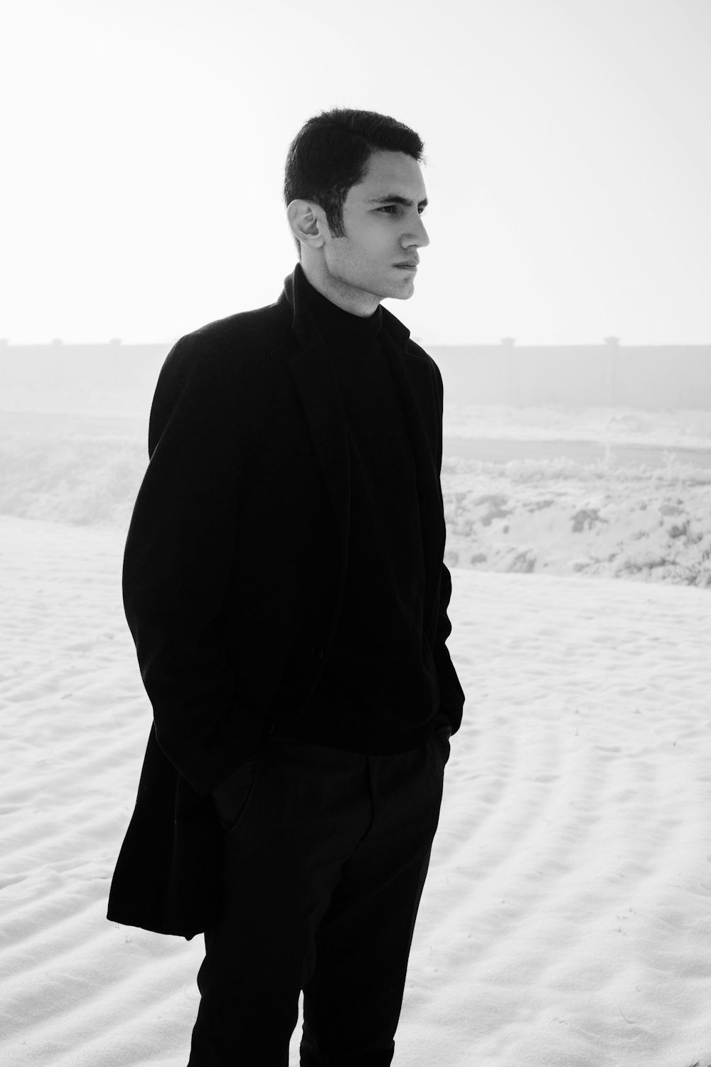 man in black coat standing on sand during daytime