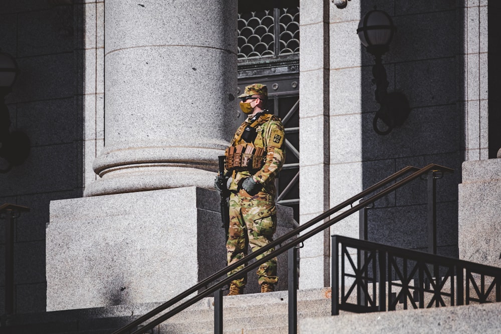 Homme en costume or et noir debout sur un escalier noir