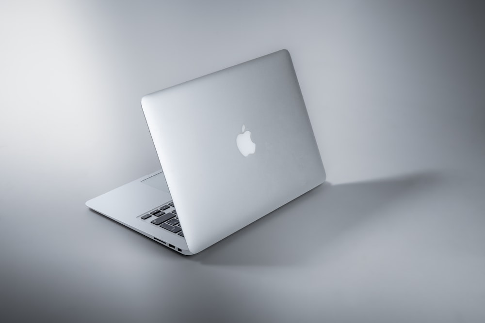 MacBook argenté sur table blanche