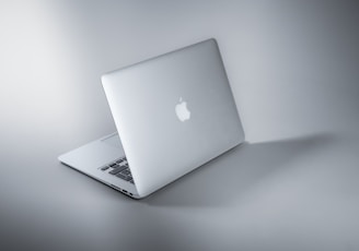 silver macbook on white table