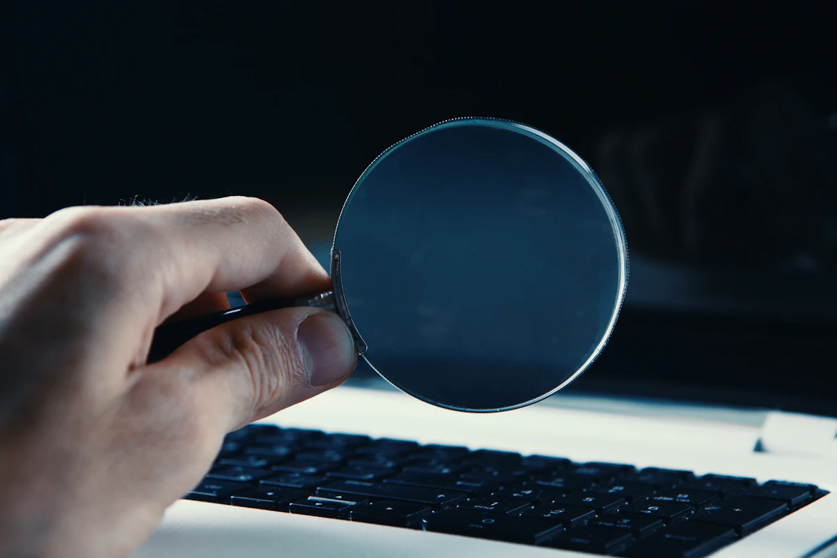 Lupa sobre líneas de código que simbolizan la búsqueda y análisis de fallos de software.