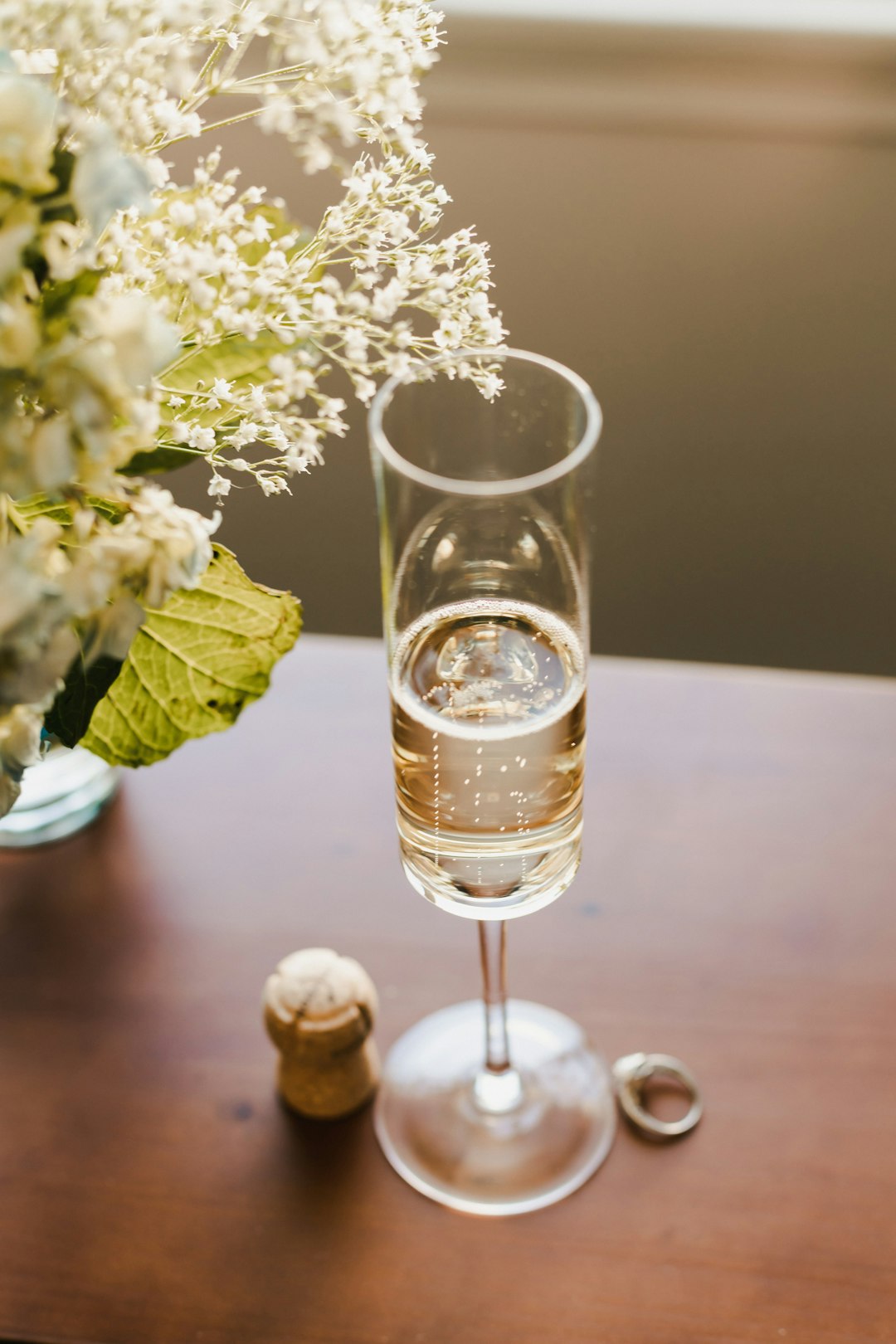 clear glass cup with beer beside white flowers