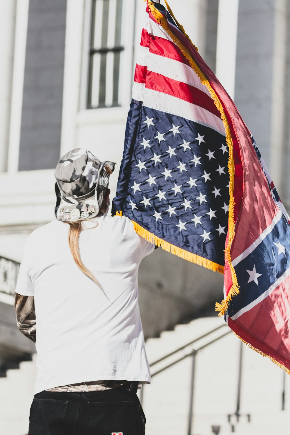 woman in white long sleeve shirt holding us a flag