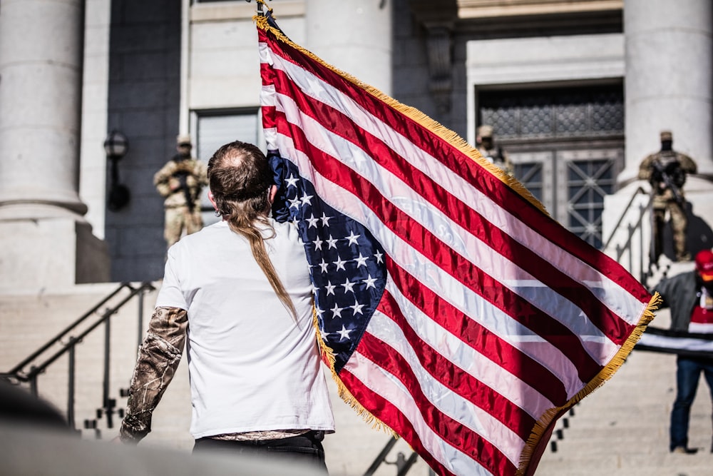 woman in white shirt holding us a flag