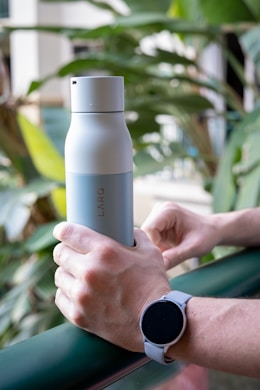 person holding white and gray reusable bottle
