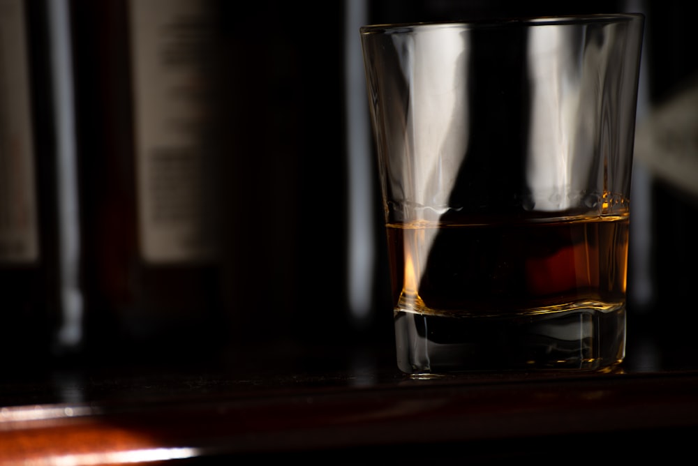 clear shot glass with brown liquid