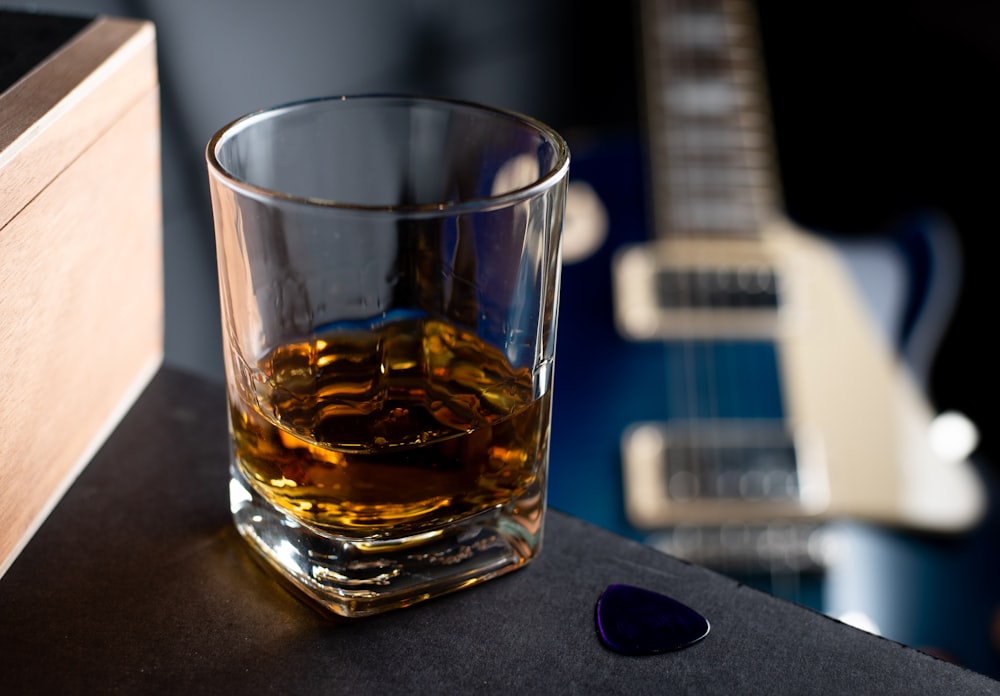 clear shot glass with brown liquid