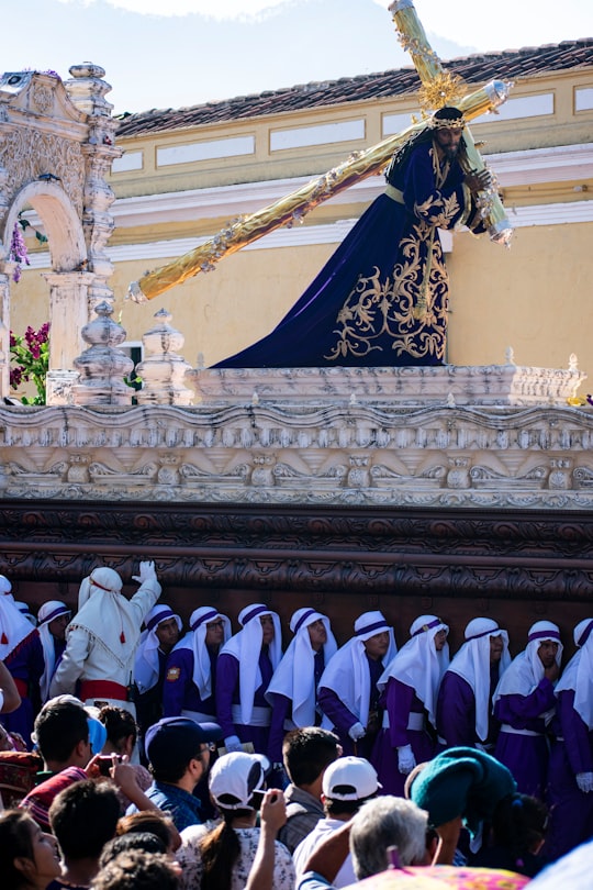 people in white and blue robe standing on white concrete building during daytime in Antigua Guatemala Guatemala