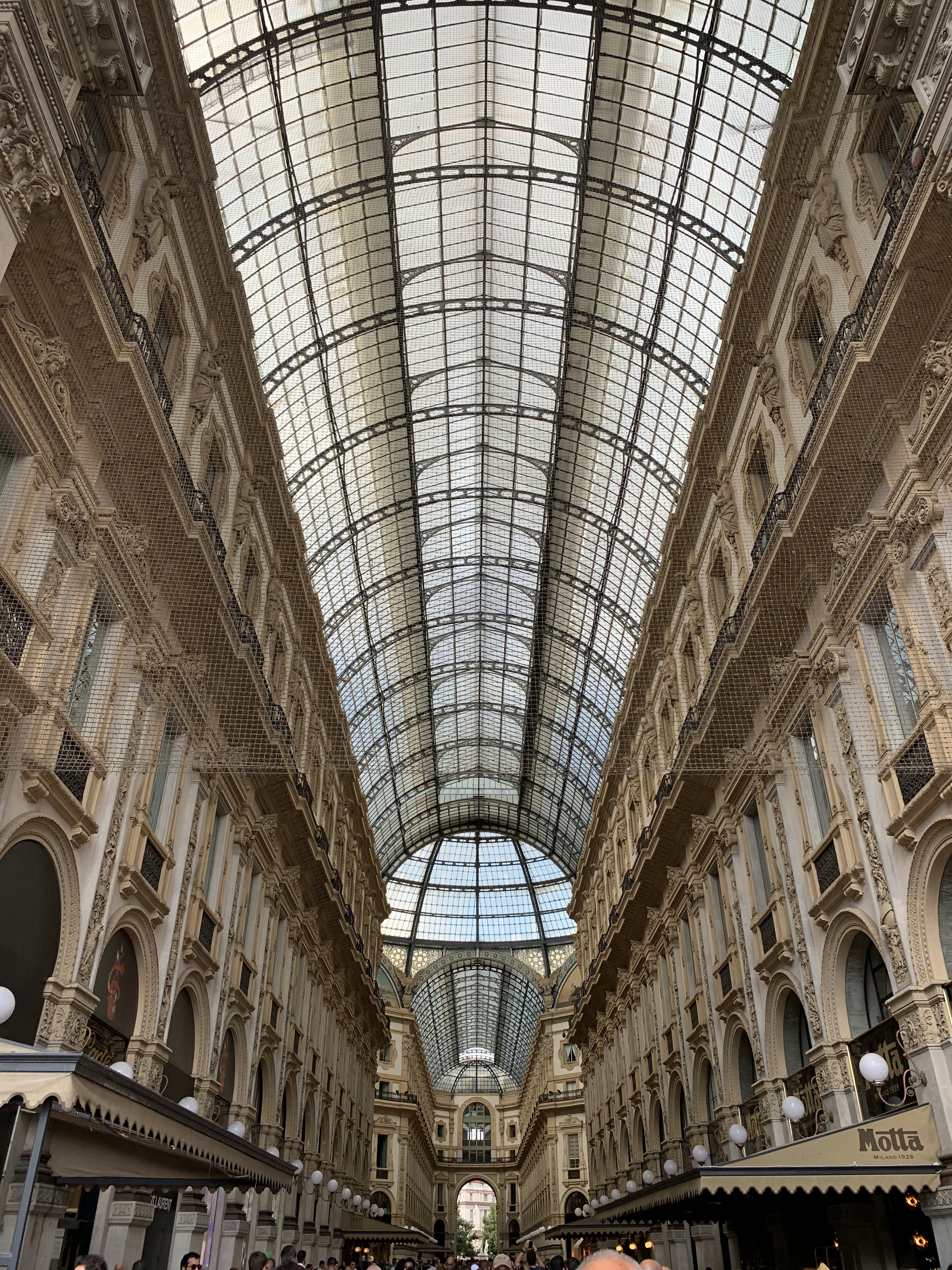 Grand architectural interior with soaring ceilings, geometric steel trusses, and expansive glazed facades