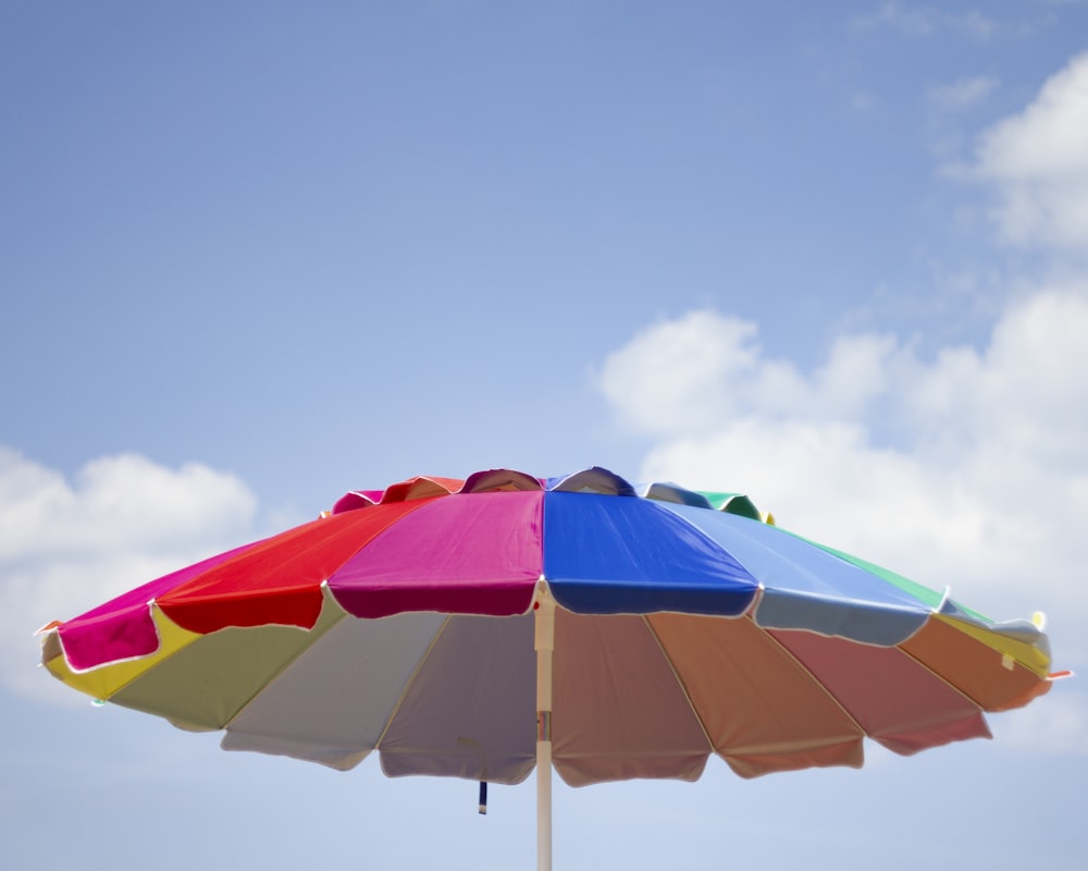 blue green and orange umbrella under blue sky during daytime