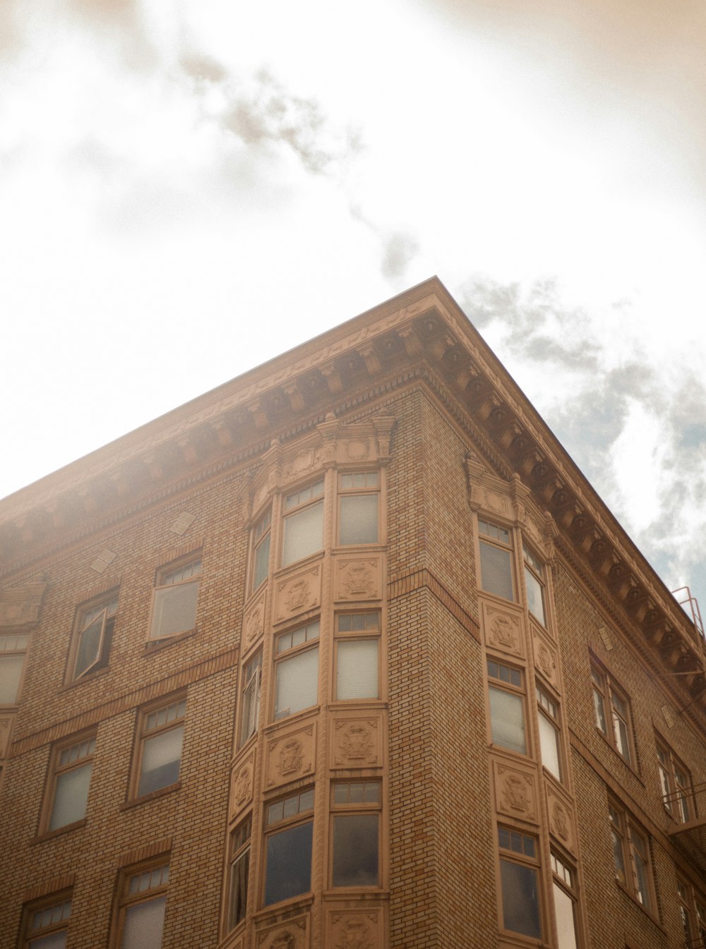 brown concrete building under white clouds during daytime