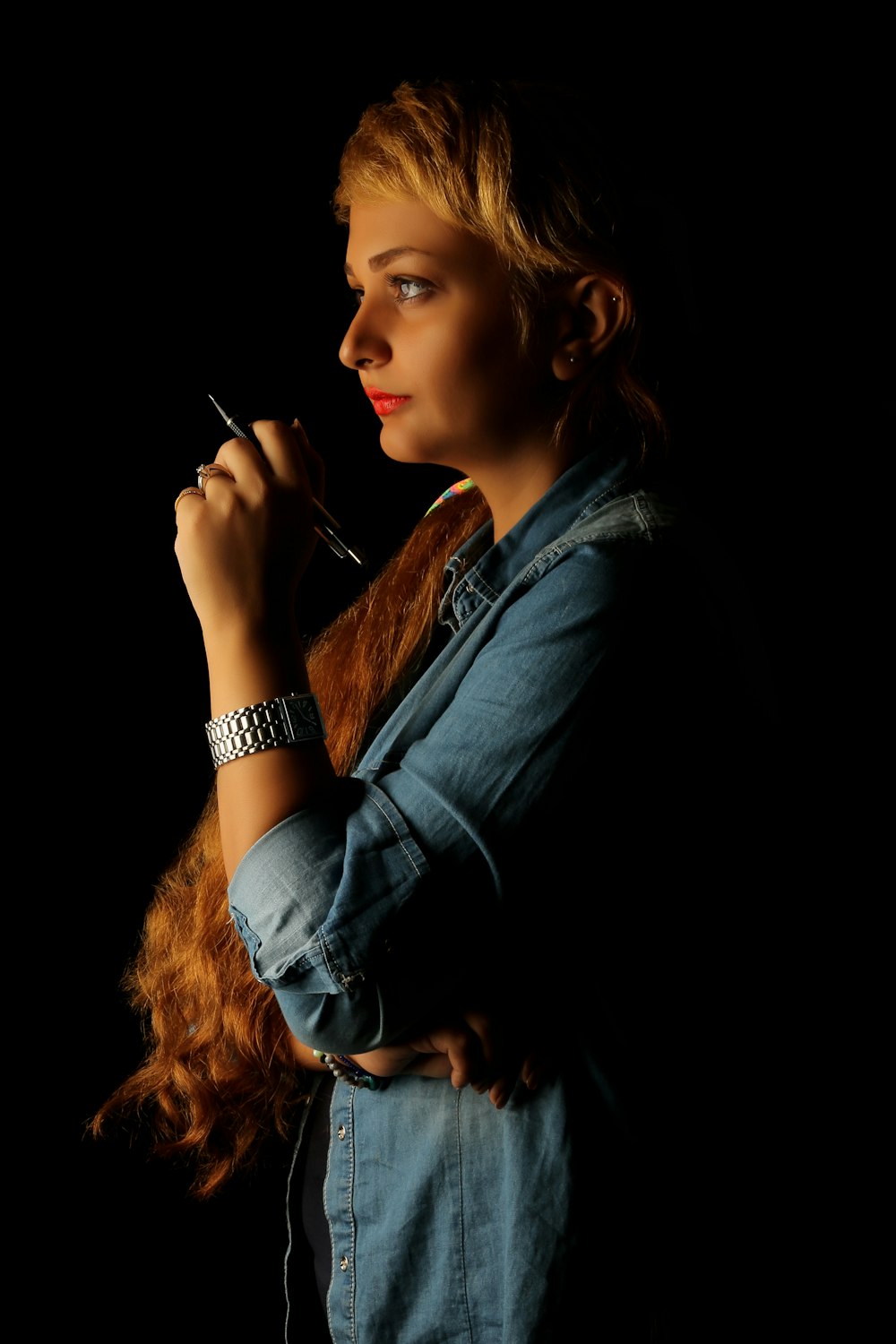 mulher na camisa preta de manga comprida que fuma o cigarro