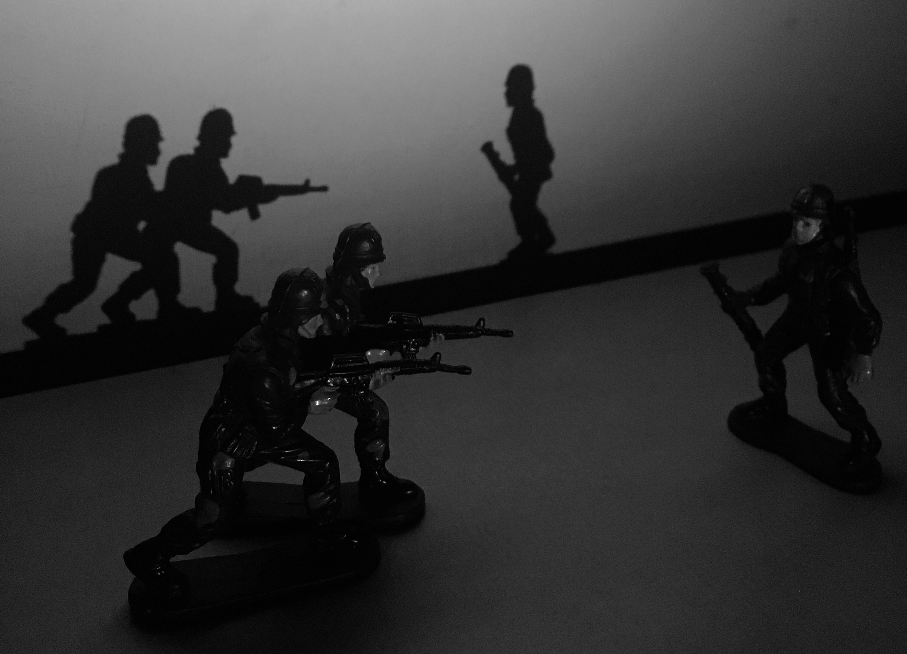 Colorful toy figures on dark background, moody dim lighting with deep shadows