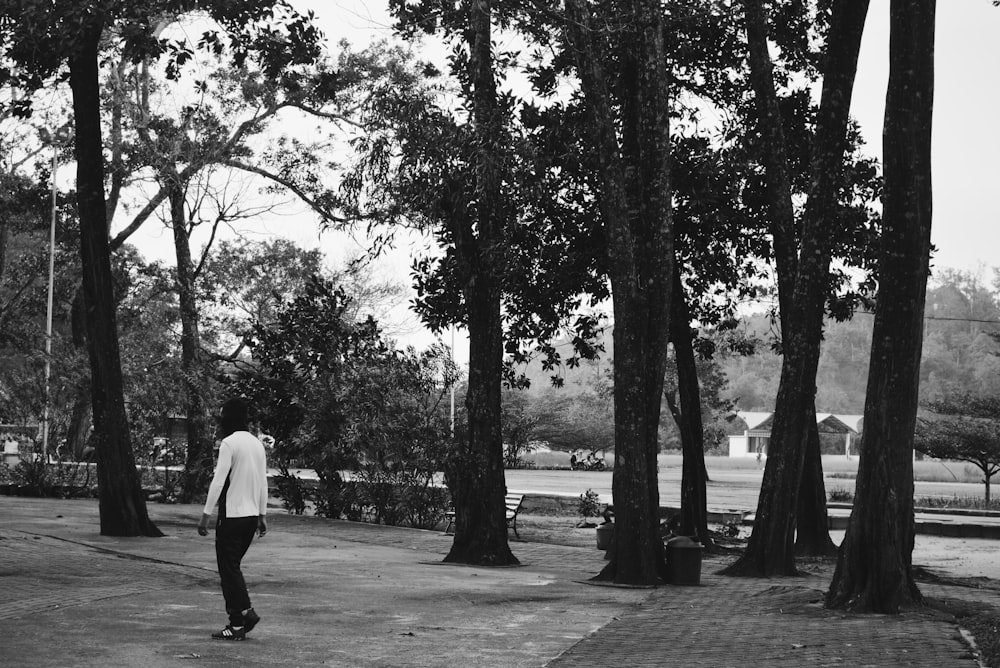 man in white dress shirt and black pants walking on park