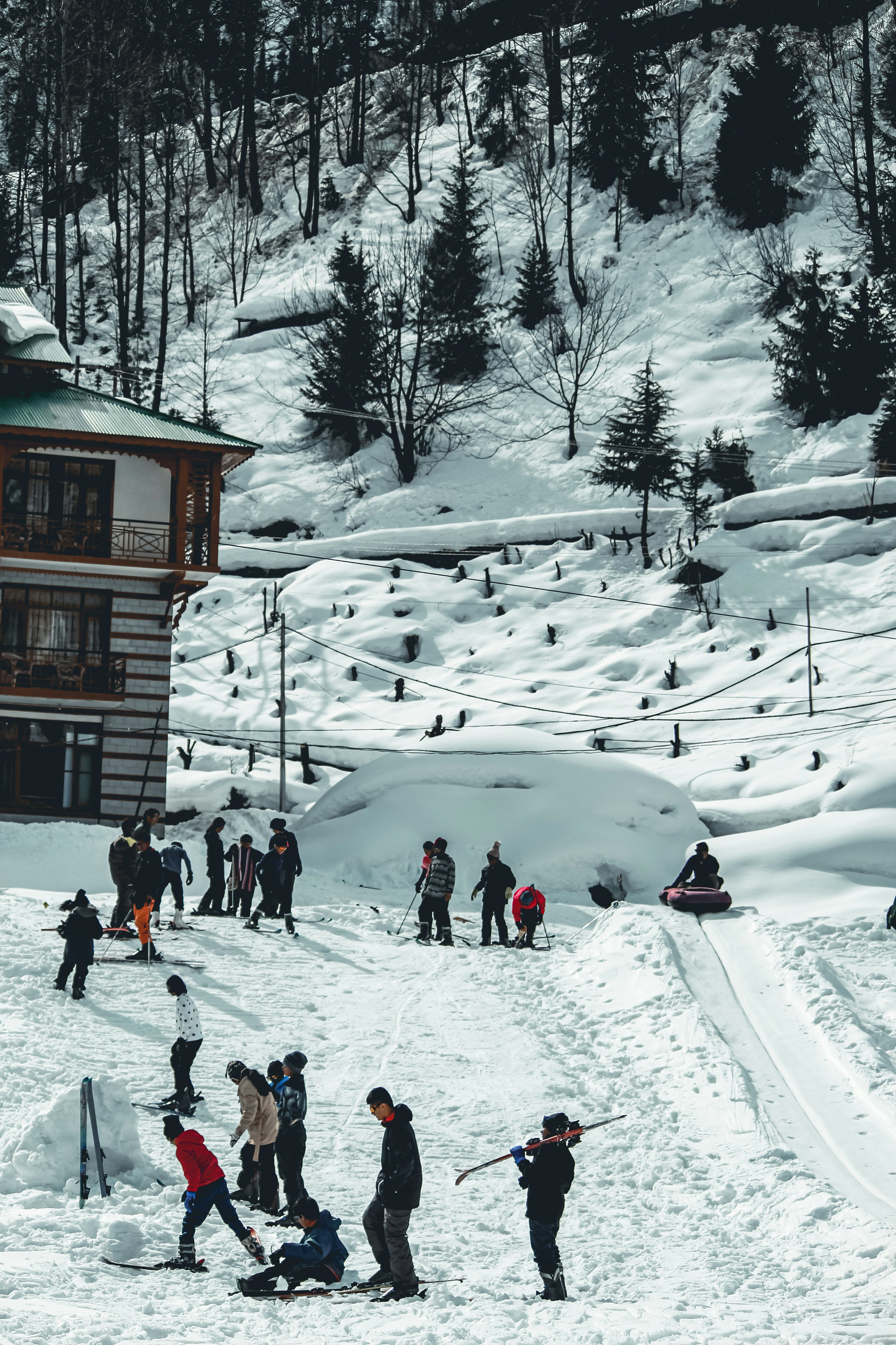 people walking on snow covered ground near brown wooden house during daytime