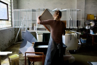 woman in brown t-shirt and black pants holding brown paper bag