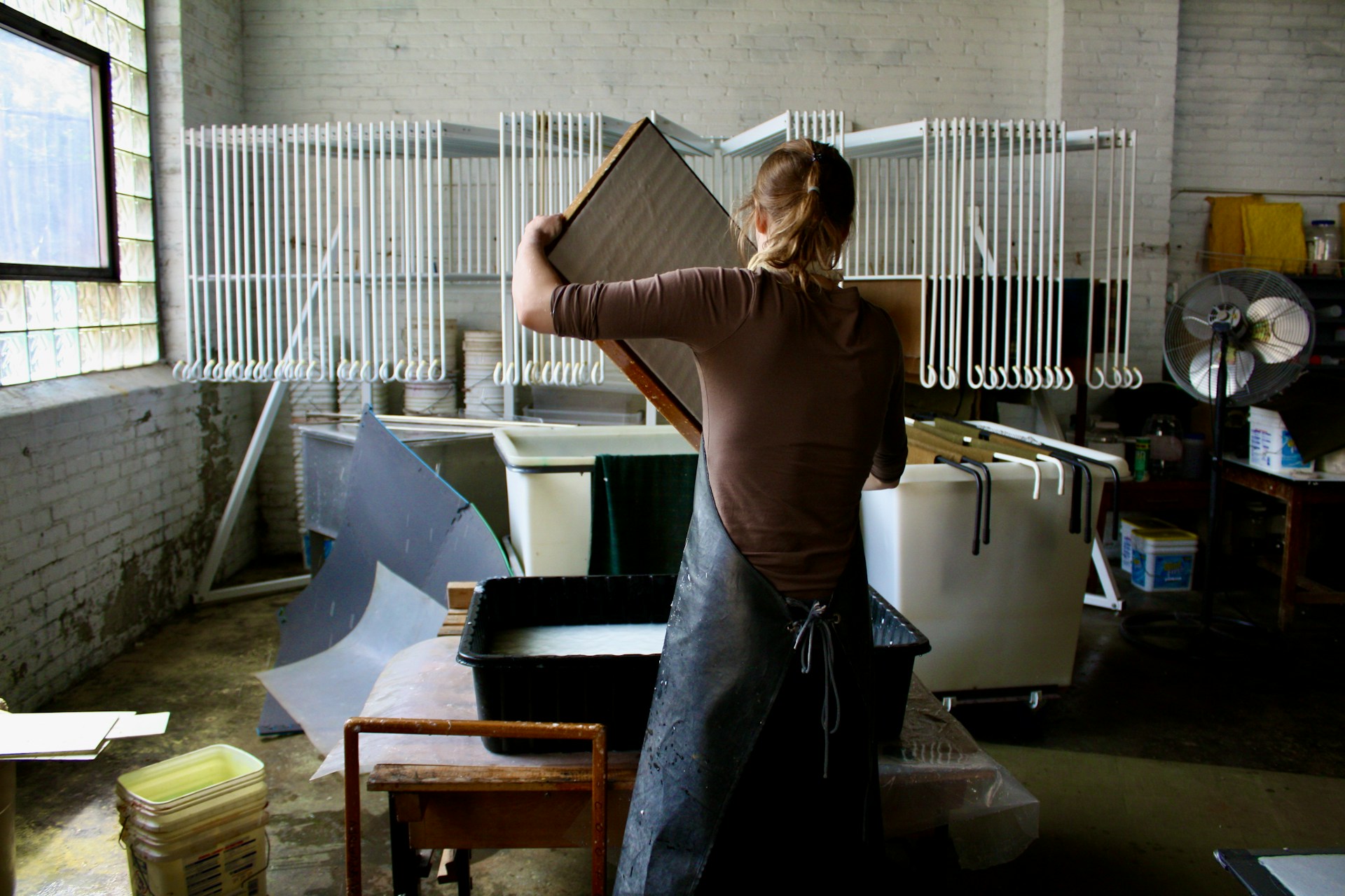 woman in brown t-shirt and black pants holding brown paper bag