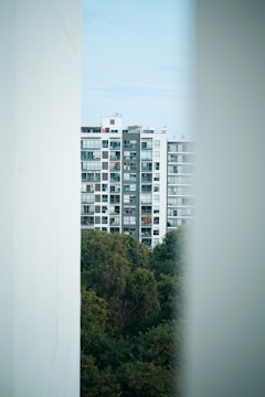 A high-rise apartment tower in Gurugram surrounded by greenery.