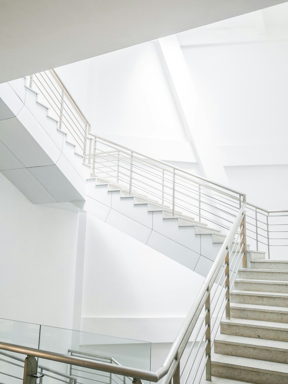 white concrete staircase with stainless steel railings