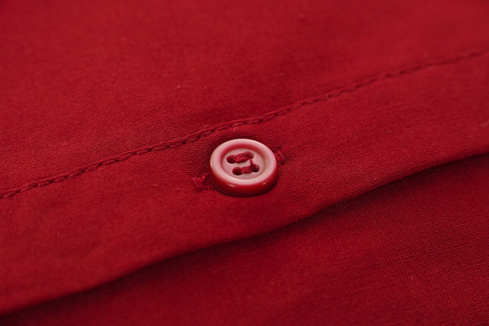 Silbernes rundes Ornament auf rotem Textil