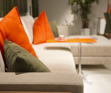 orange throw pillow on white couch