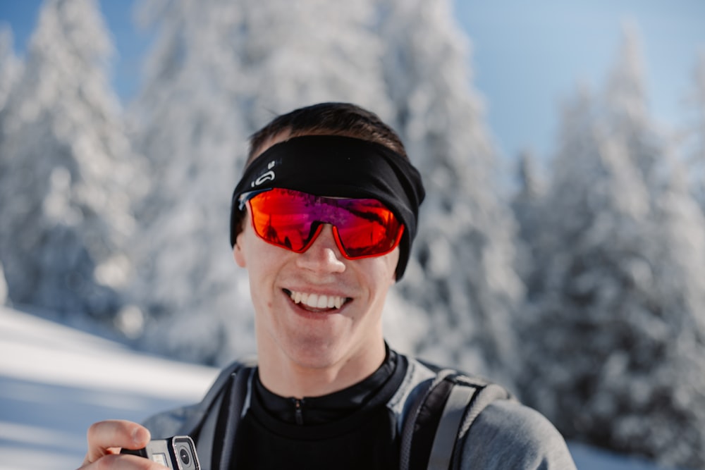 a man wearing ski goggles and holding a cell phone