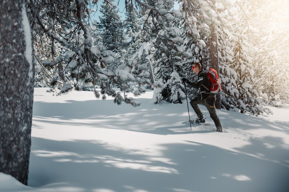 a man riding skis across a snow covered forest
