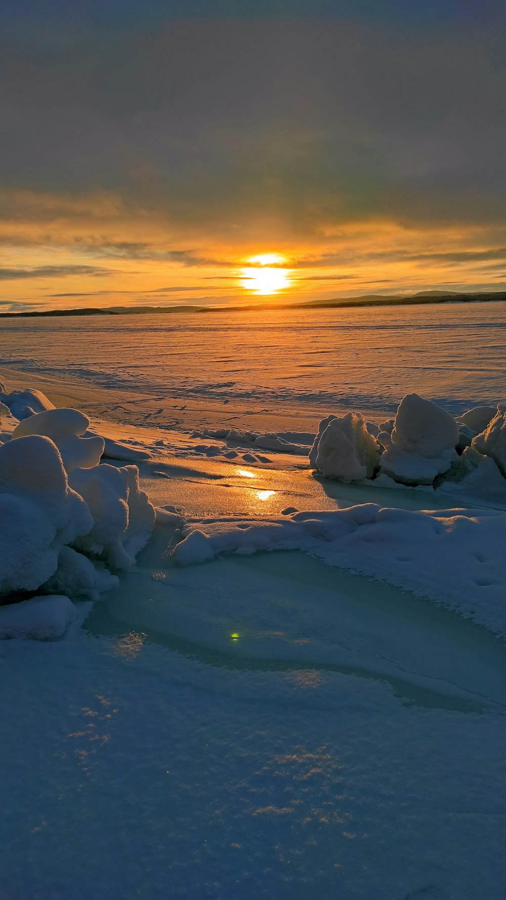 ice blocks on snow covered ground during sunset
